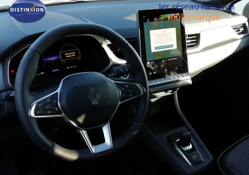 Vue intérieure centrée sur le volant et l’écran tactile du Renault Captur E-Tech hybride, ambiance noire et moderne.