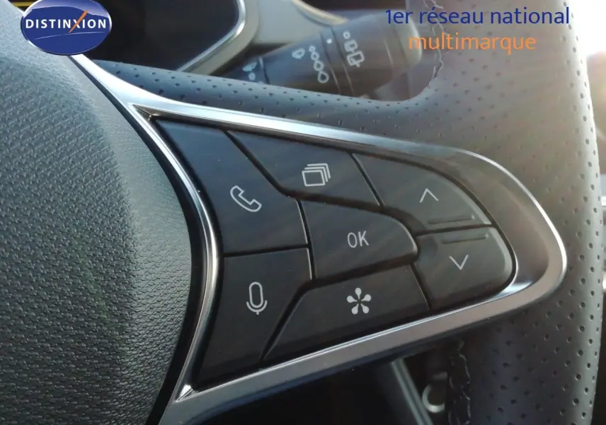 Gros plan sur les commandes au volant perforé du Renault Captur noir étoile métal, version hybride 2026.