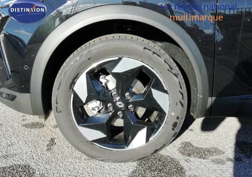 Gros plan sur la roue avant gauche du Renault Captur noir étoile métal, avec jante bi-ton noire et argentée.