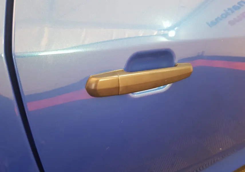 Poignée de porte côté gauche sur une Aixam Ambition 0.5 City Sport bleu 2026 avec finition mate.