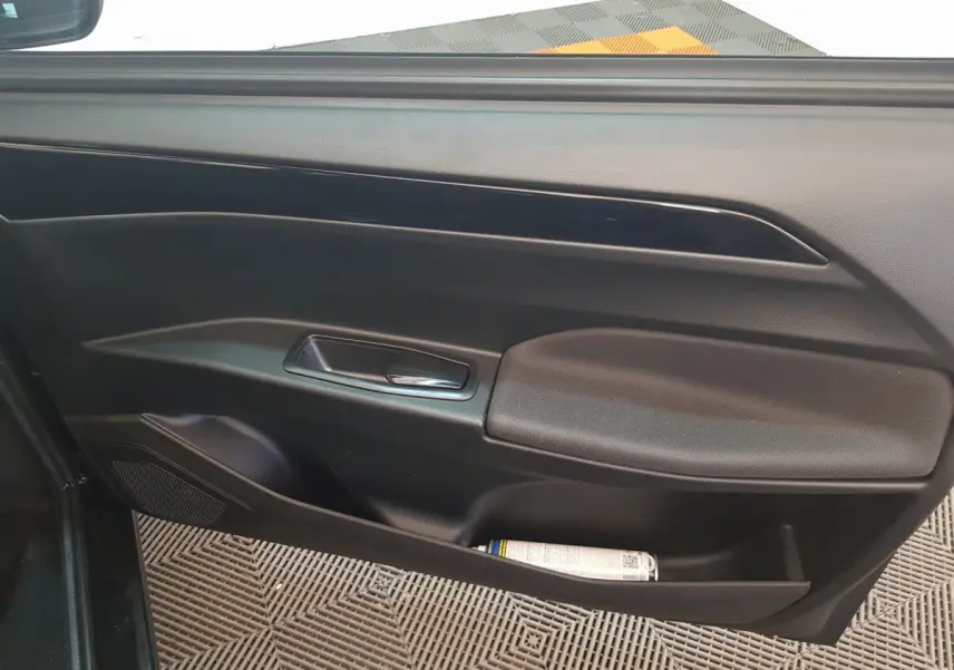 Vue intérieure de la porte côté conducteur de l'AIXAM AMBITION 0.5 CITY SPORT 2026, avec poignée et rangement noir.