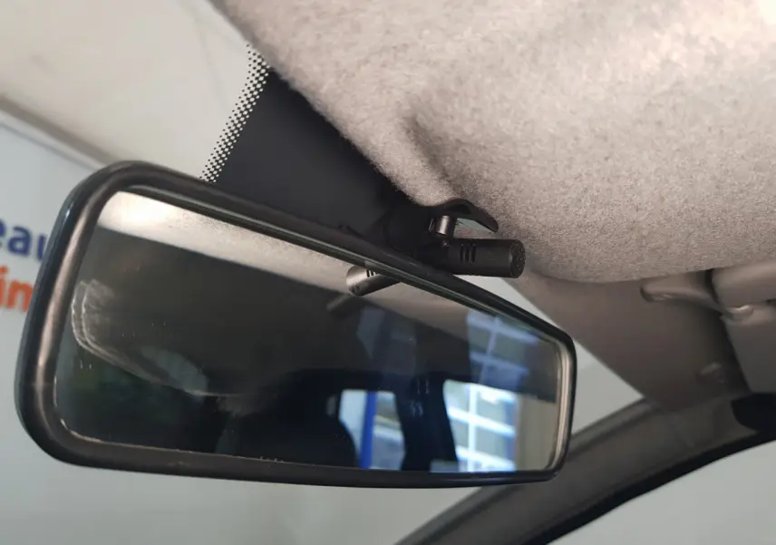 Gros plan sur la caméra intégrée au rétroviseur intérieur de l'AIXAM AMBITION 0.5 CITY SPORT bleu, côté conducteur.