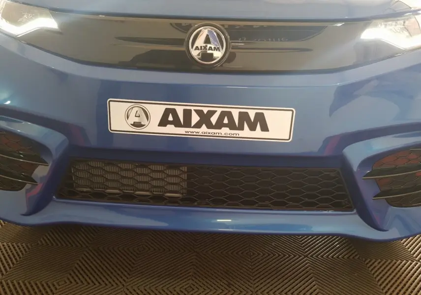 Gros plan sur la calandre avant bleue de l'AIXAM AMBITION 0.5 CITY SPORT avec logo et plaque AIXAM visible.