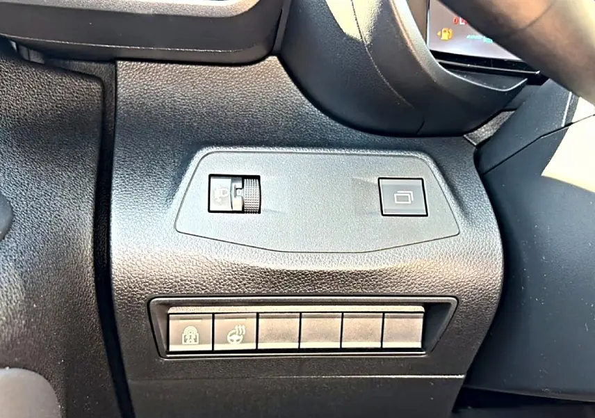 Gros plan sur les commandes noires à gauche du volant dans l’habitacle du Citroën Berlingo gris acier 2026.