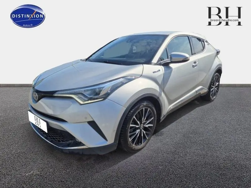 Toyota C-HR gris aluminium en 3/4 avant droit avec jantes alliage et lignes anguleuses distinctives.
