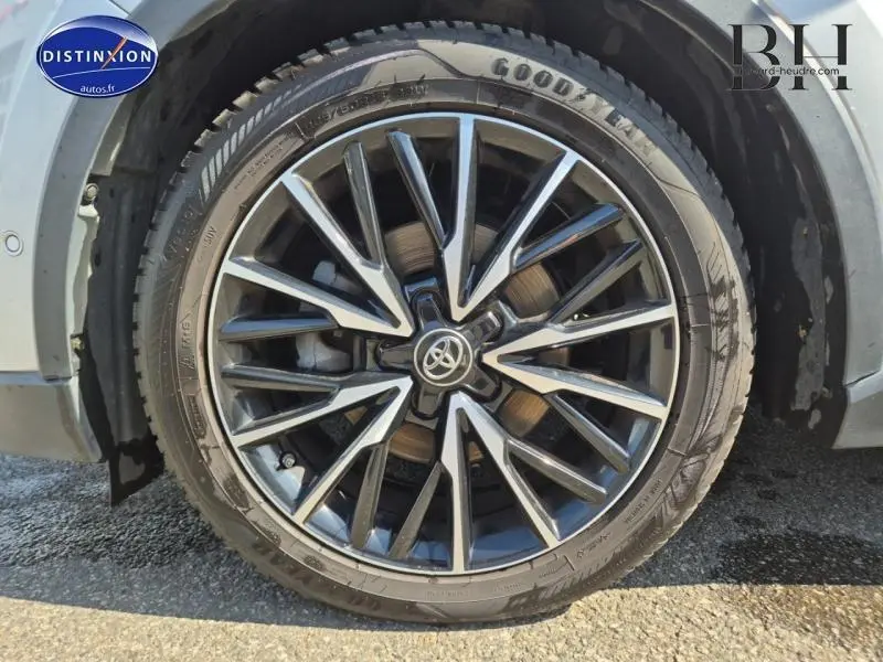 Gros plan sur la jante alu noire et argentée du Toyota C-HR gris aluminium, mettant en valeur le logo Toyota central.