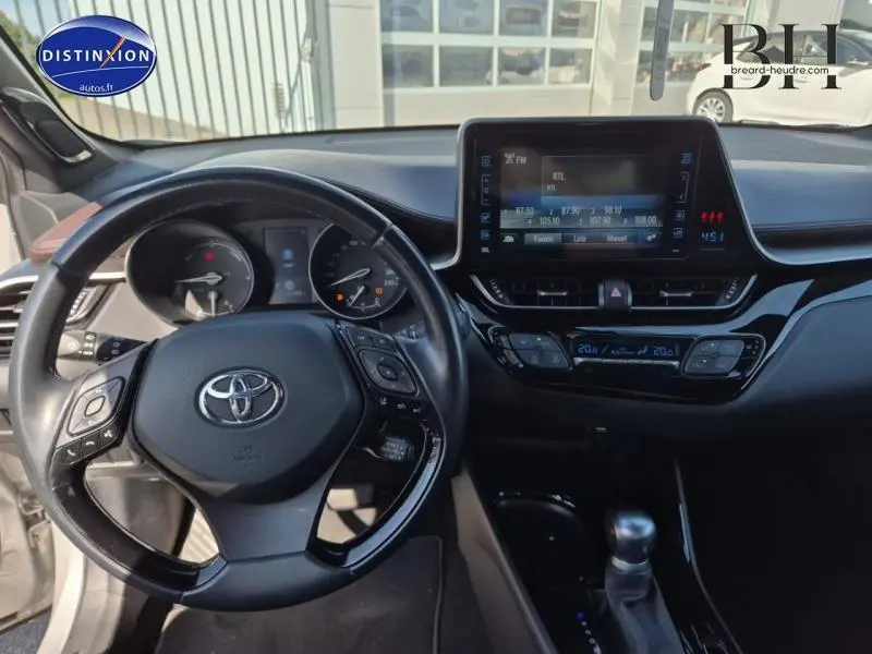 Intérieur du Toyota C-HR 122h Distinctive 2WD 2019, vue du poste de conduite avec volant multifonction et écran tactile central.