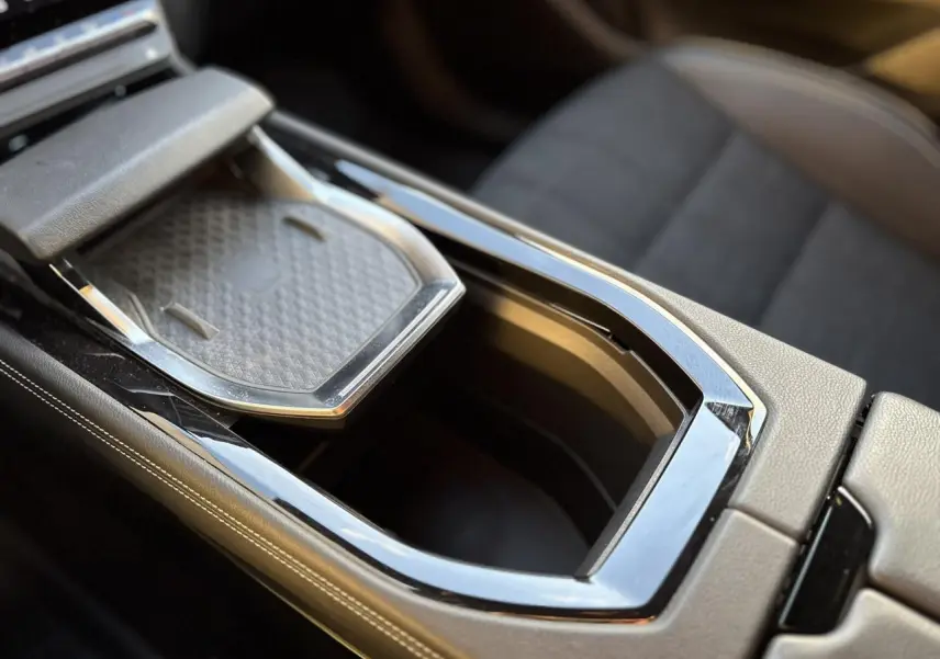 Gros plan sur la console centrale du Renault Austral 2023 avec compartiment ouvert et finition cuir beige.