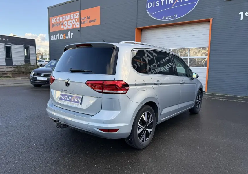 Volkswagen Touran argent Dolomite vu en 3/4 arrière droit avec jantes alliage et attelage escamotable