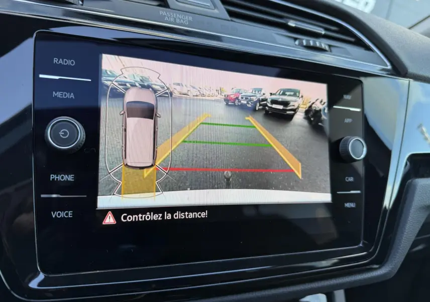 Écran tactile intérieur montrant la caméra de recul et l'aide au stationnement du Volkswagen Touran argent Dolomite 2025.