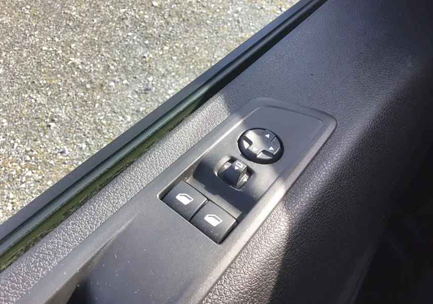 Gros plan sur les commandes de lève-vitres et réglage des rétroviseurs côté conducteur du FIAT Scudo Fourgon blanc 2024.