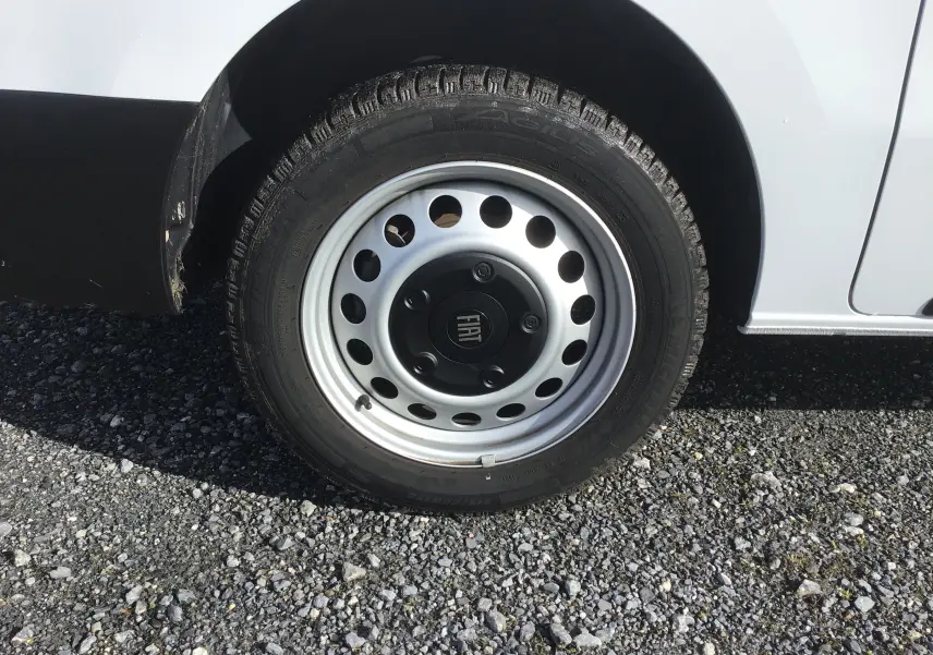 Gros plan sur la roue avant droite blanche du FIAT Scudo Fourgon 2024 avec jante acier et logo FIAT central.