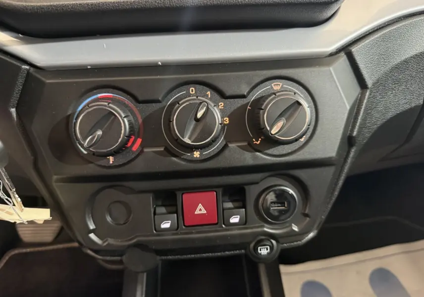 Gros plan sur les commandes de climatisation et les boutons de l’AIXAM AMBITION 0.5 CROSSOVER PREMIUM gris foncé, tableau de bord intérieur.