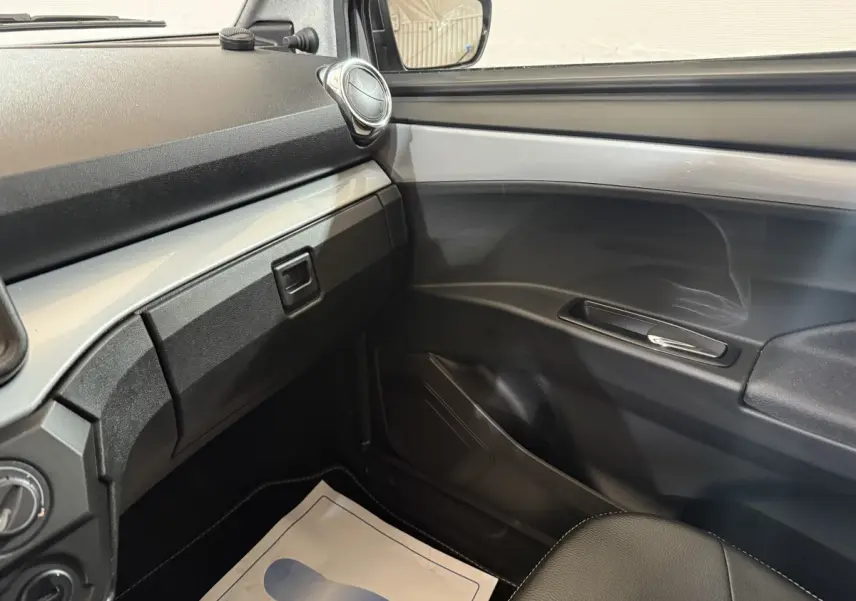 Vue intérieure côté passager de l’AIXAM AMBITION 0.5 CROSSOVER PREMIUM 2026, tableau de bord et porte gris foncé.