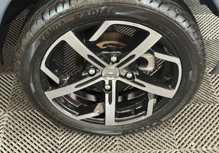 Gros plan sur la jante noire et argentée d’une Aixam Ambition 0.5 Crossover Premium gris foncé, roue avant.