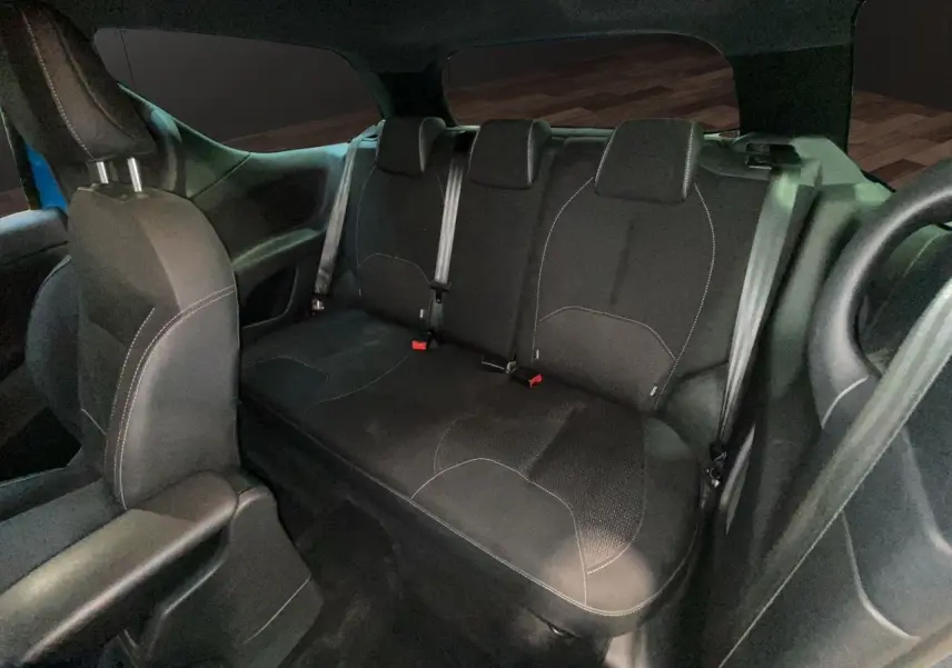 Vue intérieure arrière montrant la banquette arrière en tissu noir de la Citroën DS3 2011 avec ceintures de sécurité visibles.