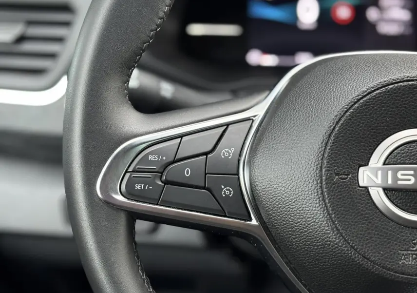 Gros plan sur le volant noir du Nissan Primastar Combi 2025, mettant en valeur les commandes de régulateur de vitesse.