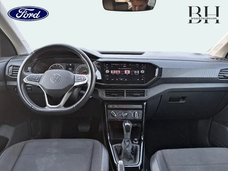 Intérieur noir du Volkswagen T-Cross 2022, vue frontale sur le tableau de bord et volant multifonction cuir.