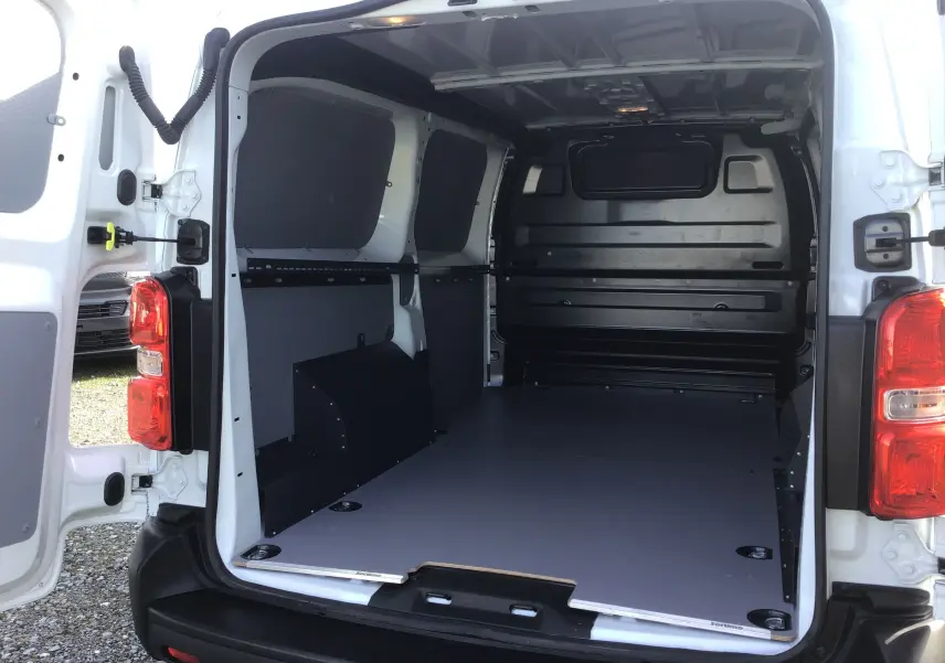 Vue arrière ouverte du fourgon blanc FIAT Scudo XL 2024, intérieur utilitaire avec revêtement PVC et protection tôlée.