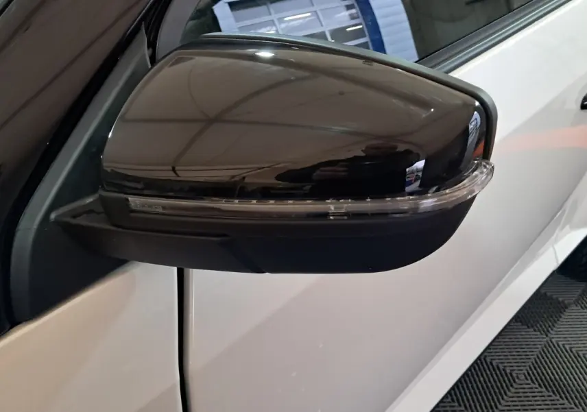 Gros plan sur le rétroviseur caméra côté gauche noir brillant d'une Aixam Ambition 0.5 City Coupe GTI blanche.