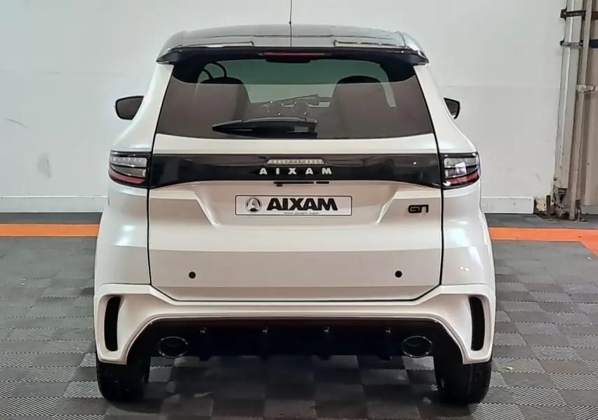 Vue arrière d'une Aixam Ambition 0.5 City Coupe GTI blanche avec bande noire et double sortie d'échappement.