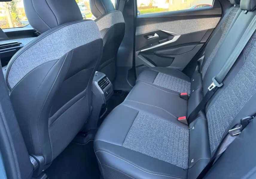 Vue intérieure arrière côté droit du Peugeot 3008 Hybrid 136ch Allure 2025, sièges tissu gris et cuir noir.