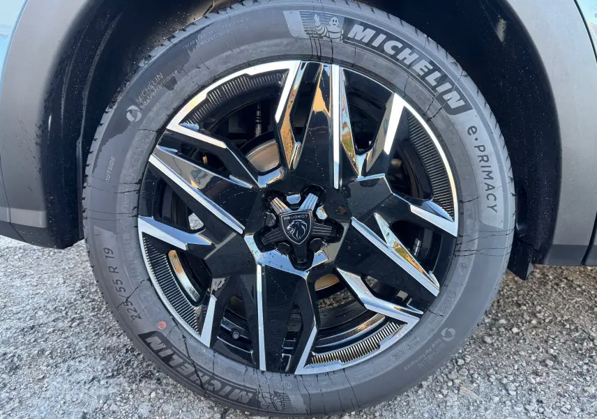 Gros plan sur la jante avant droite noire et argentée du Peugeot 3008 Hybrid 136ch Bleu Nogaro avec pneu Michelin.