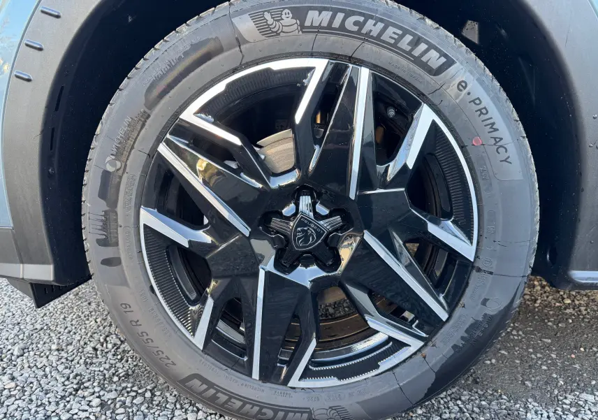 Gros plan sur la jante noire et argentée du Peugeot 3008 Bleu Nogaro, mettant en valeur le logo lion central.