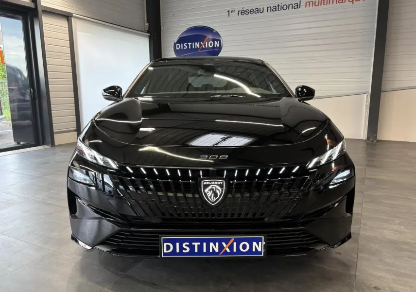 Vue avant d'une Peugeot 308 GT noire métallisée avec calandre noire brillante et logo lion lumineux.