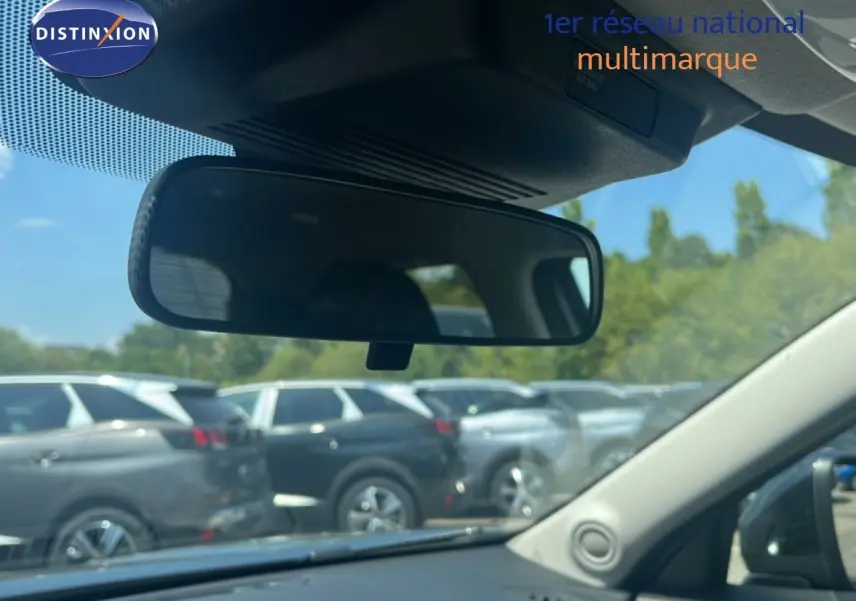 Vue intérieure du rétroviseur central d'un Nissan Juke gris, avec plusieurs SUV garés en arrière-plan.