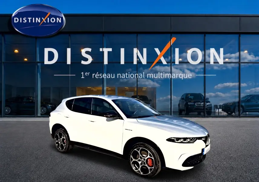 Alfa Romeo Tonale blanc en 3/4 avant droit, jantes alu distinctives et vitres arrière surteintées, devant showroom Distinxion.