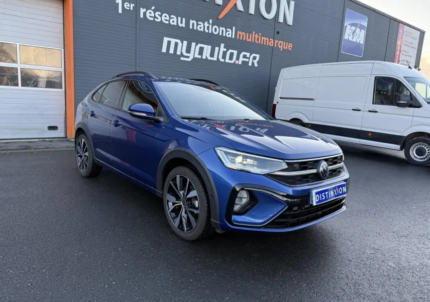 Volkswagen Taigo R-Line bleu récif métallisé en 3/4 avant droit avec jantes noires brillantes et calandre marquée R-Line.