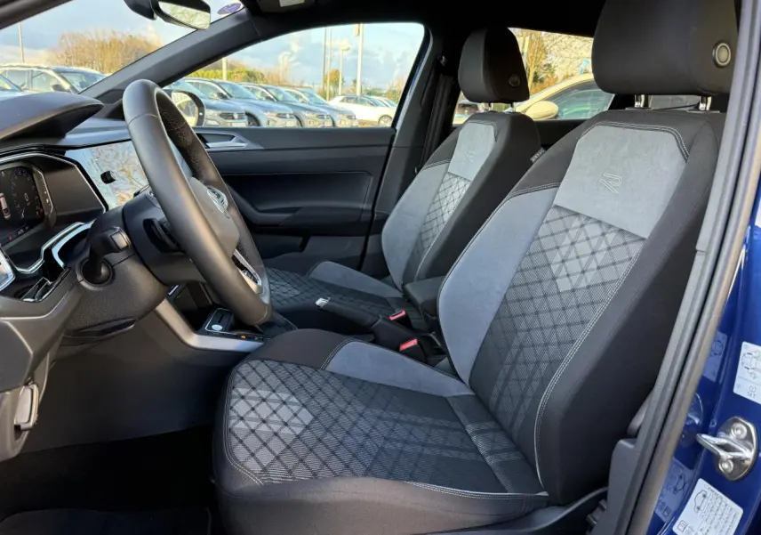 Intérieur côté conducteur du Volkswagen Taigo bleu récif, sièges R-Line en tissu et alcantara gris à motifs géométriques.