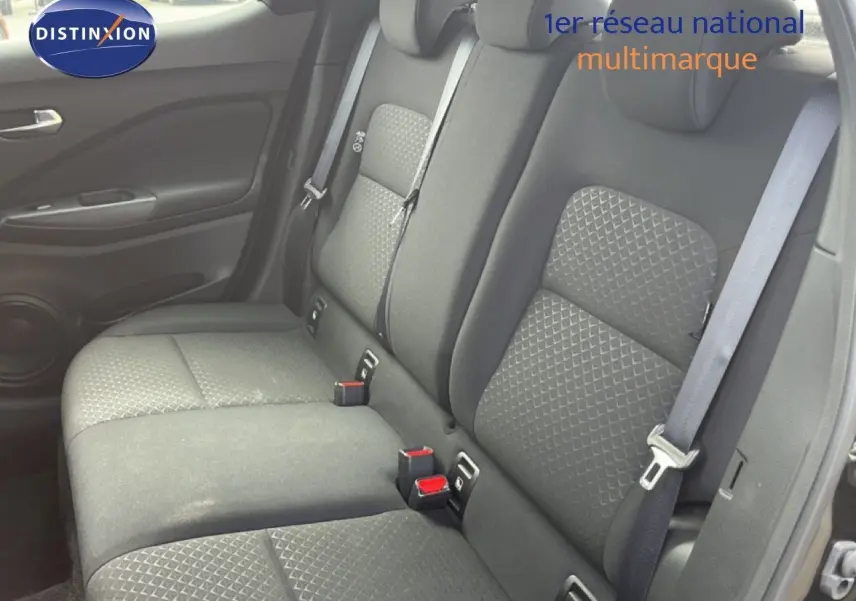 Vue intérieure côté droit des sièges arrière en tissu noir du Nissan Juke 2023, avec ceintures de sécurité visibles.