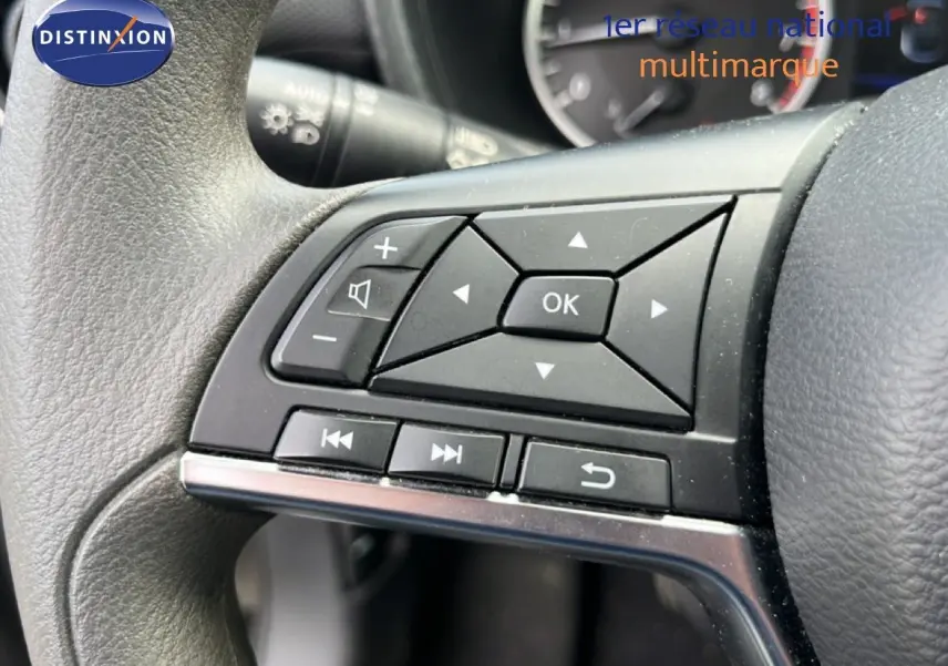 Gros plan sur les commandes multifonctions à gauche du volant du Nissan Juke 2023 noir métal, avec boutons directionnels et audio.