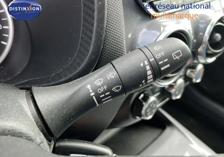 Gros plan sur la commande d’essuie-glace à gauche du volant dans l’habitacle noir du Nissan Juke 2023.