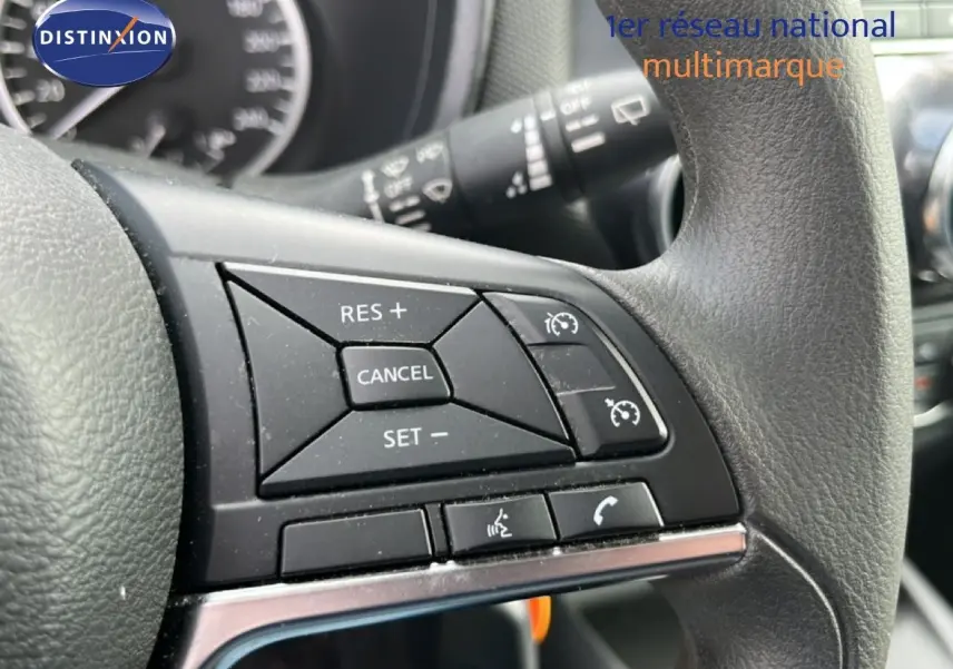 Gros plan sur les commandes au volant du Nissan Juke 2023 noir métal, mettant en valeur les boutons de régulateur de vitesse et téléphone.