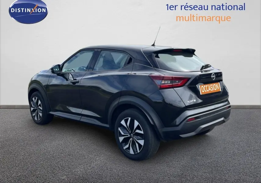 Nissan Juke noir métal vu en 3/4 arrière côté gauche, soulignant ses lignes modernes et ses jantes stylisées.