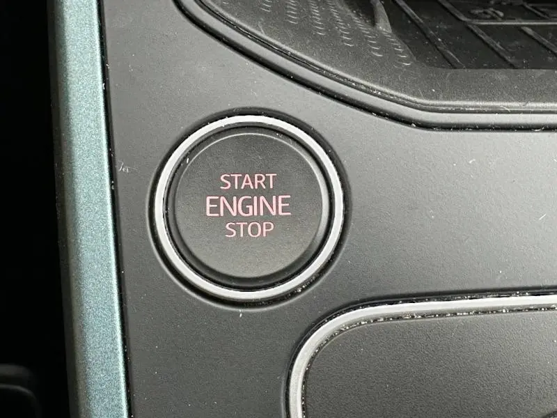 Gros plan sur le bouton Start Engine Stop du SEAT Arona 2025, intérieur noir avec finitions argentées.