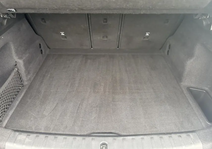 Vue intérieure du coffre spacieux et propre du BMW X1 blanc Mineral 2025, avec revêtement gris foncé.
