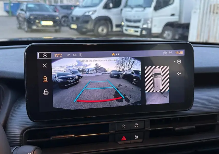 Écran de caméra de recul du Jeep Avenger noir montrant l'arrière avec guidage de trajectoire en bleu et rouge.
