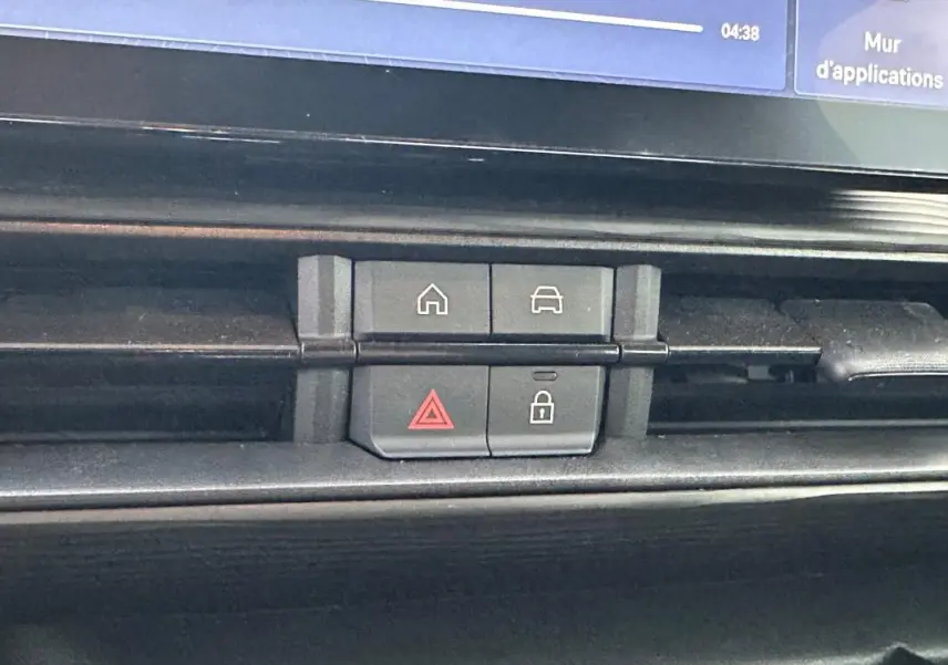 Boutons de commande du tableau de bord du Jeep Avenger noir, avec icônes maison, voiture, alerte et verrouillage.