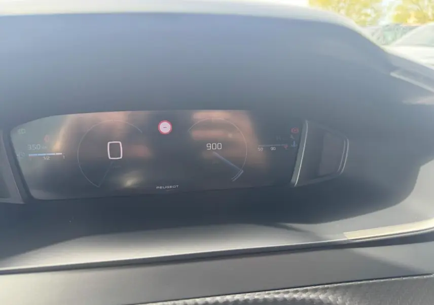 Vue rapprochée du cockpit numérique du Peugeot 2008 blanc 2024, affichant vitesse et compte-tours.