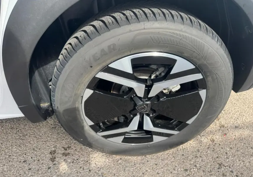 Gros plan sur la jante alliage noire et argent de 17 pouces du Peugeot 2008 blanc, avec pneu Goodyear visible.