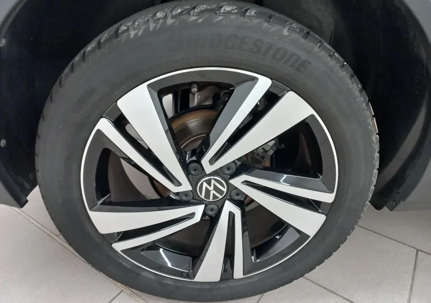 Gros plan sur la jante bicolore noire et argentée du Volkswagen T-Roc 1.5 TSI 2025 Noir Intense nacré.