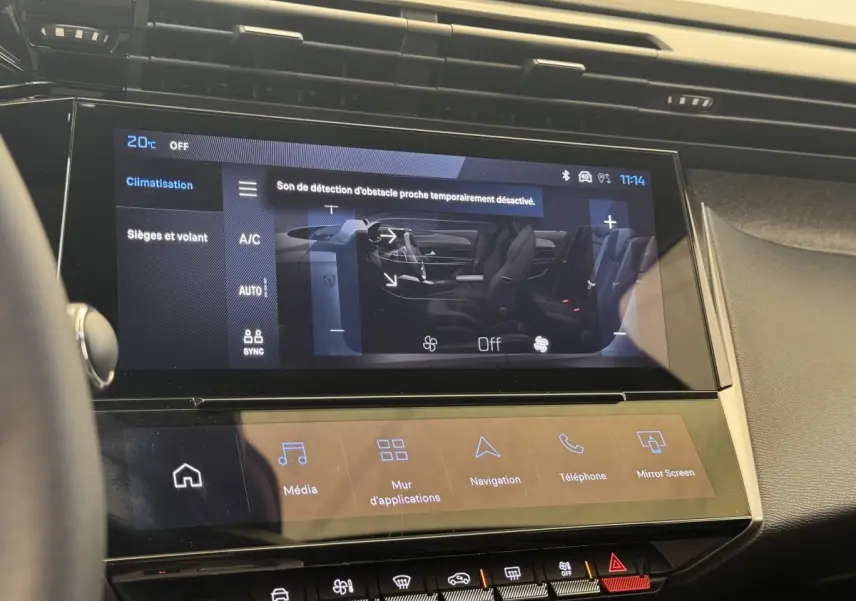 Écran tactile central de la Peugeot 308 gris clair, affichant les réglages climatisation et sièges, vue intérieure frontale.