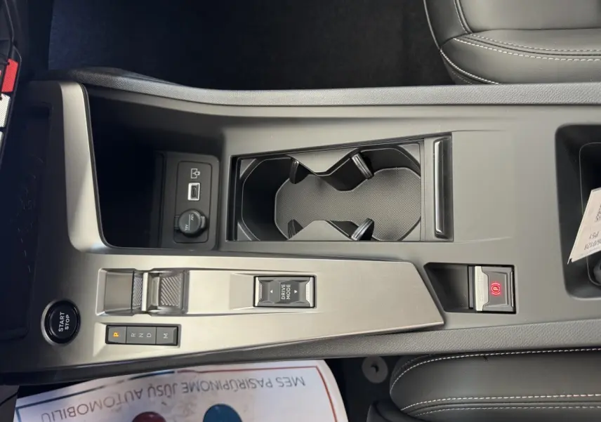 Vue rapprochée de la console centrale grise claire de la Peugeot 308 2026 avec bouton start/stop et commandes boîte auto.