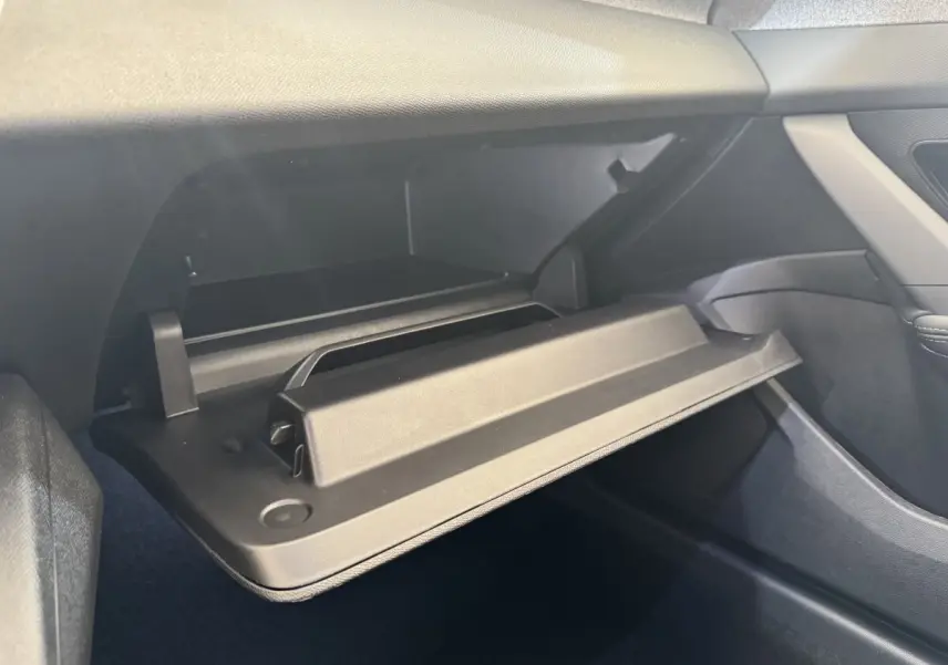 Vue intérieure côté passager montrant la boîte à gants ouverte du Peugeot 308 gris clair 2026.