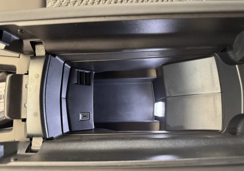 Vue plongeante sur le rangement central avant noir avec prise USB intégré dans une Peugeot 308 gris clair.