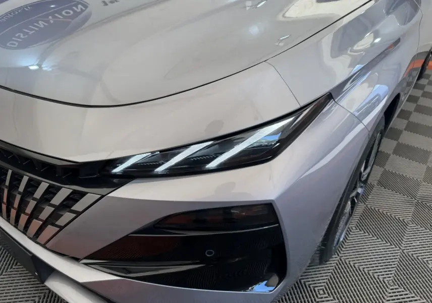 Gros plan sur l'avant droit gris clair du Peugeot 308 2026, mettant en valeur ses phares LED et sa calandre distinctive.